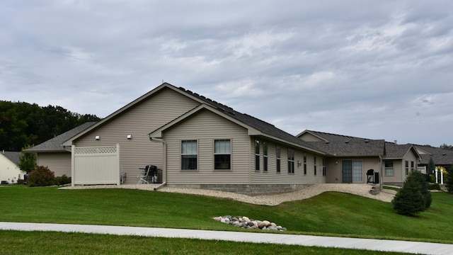 rear view of property featuring a lawn