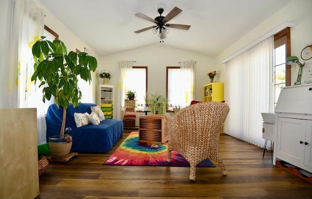 living area featuring lofted ceiling, a wealth of natural light, and dark hardwood / wood-style flooring