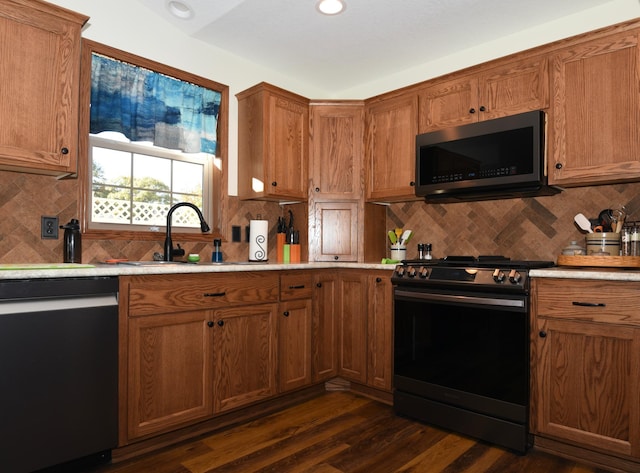 kitchen featuring stainless steel appliances, backsplash, sink, and dark hardwood / wood-style flooring