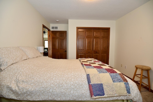 bedroom featuring a closet, carpet flooring, and a textured ceiling