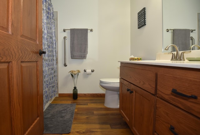 bathroom featuring wood-type flooring, vanity, and toilet