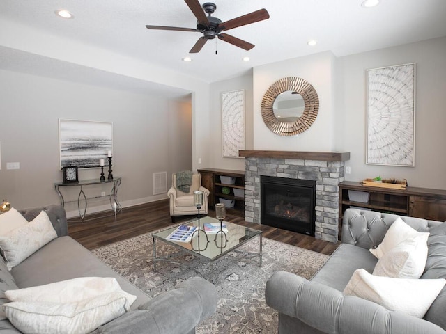 living room featuring a fireplace, dark hardwood / wood-style flooring, and ceiling fan