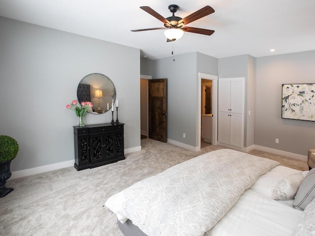 carpeted bedroom with ensuite bath and ceiling fan