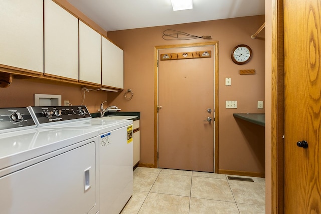 laundry area featuring sink, light tile patterned floors, cabinets, and independent washer and dryer