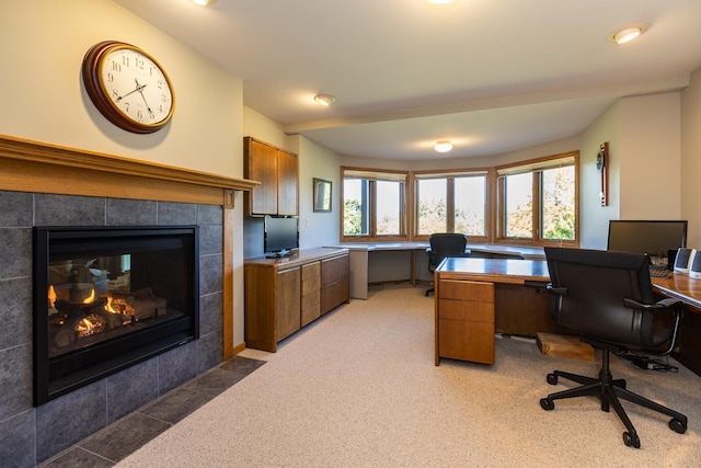 office area featuring dark carpet and a tile fireplace