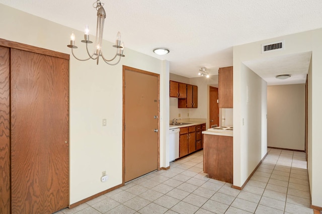 kitchen with dishwasher, hanging light fixtures, light tile patterned flooring, and sink