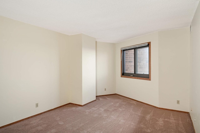 carpeted empty room featuring a textured ceiling