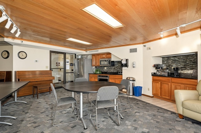 tiled dining area featuring ornamental molding, wood ceiling, and rail lighting