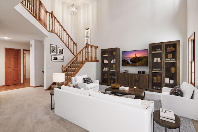 living room with an inviting chandelier, a high ceiling, and light colored carpet