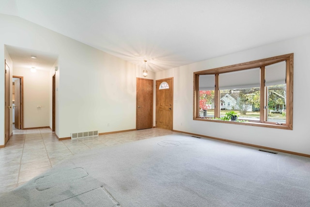 unfurnished room with lofted ceiling and light tile patterned flooring