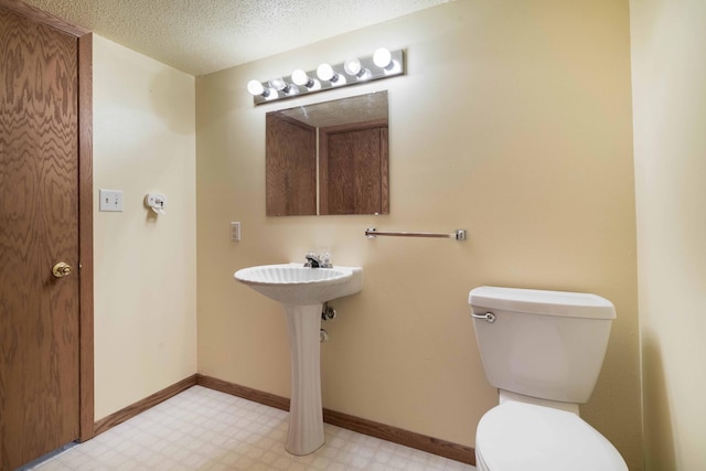 bathroom featuring a textured ceiling and toilet