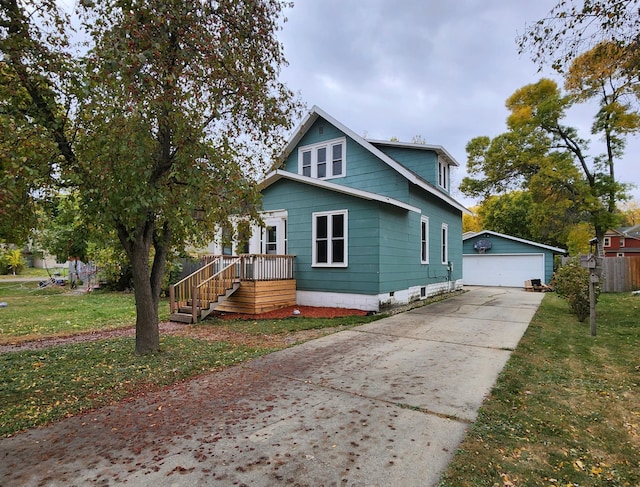 view of front of property featuring a garage, a front lawn, and an outdoor structure