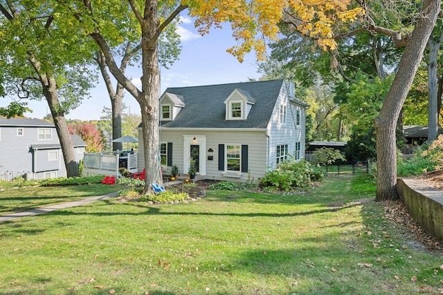 cape cod home featuring a front lawn