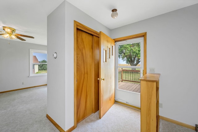 hall with light colored carpet and a healthy amount of sunlight