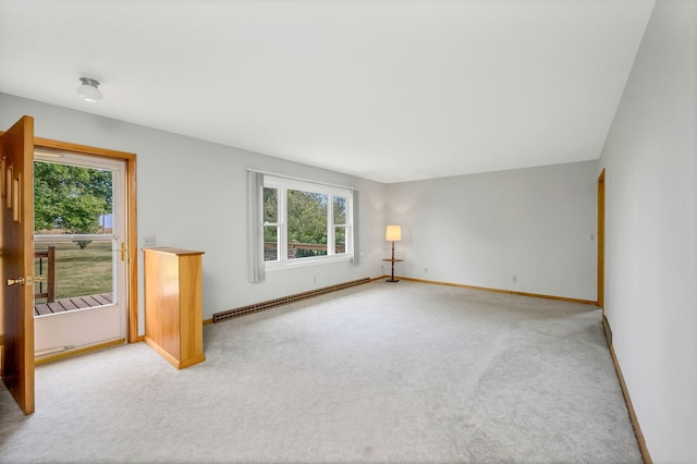 carpeted empty room featuring plenty of natural light and a baseboard heating unit