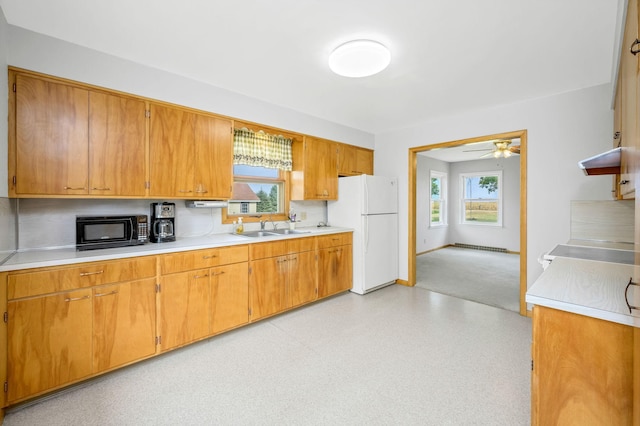 kitchen featuring ceiling fan, white refrigerator, sink, and a healthy amount of sunlight