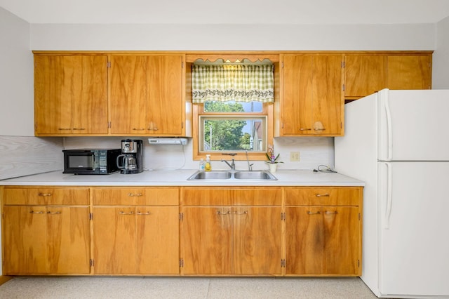 kitchen with tasteful backsplash, sink, and white fridge