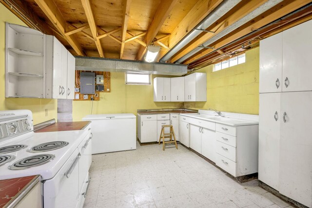 kitchen featuring white cabinetry, refrigerator, a healthy amount of sunlight, and white electric range