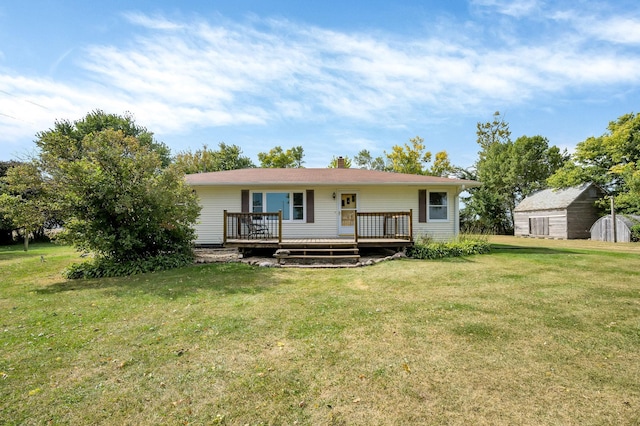 back of house with a wooden deck, a shed, and a yard