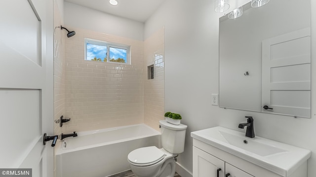 full bathroom featuring vanity, tiled shower / bath combo, and toilet