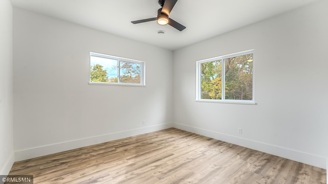 empty room with ceiling fan and light hardwood / wood-style flooring