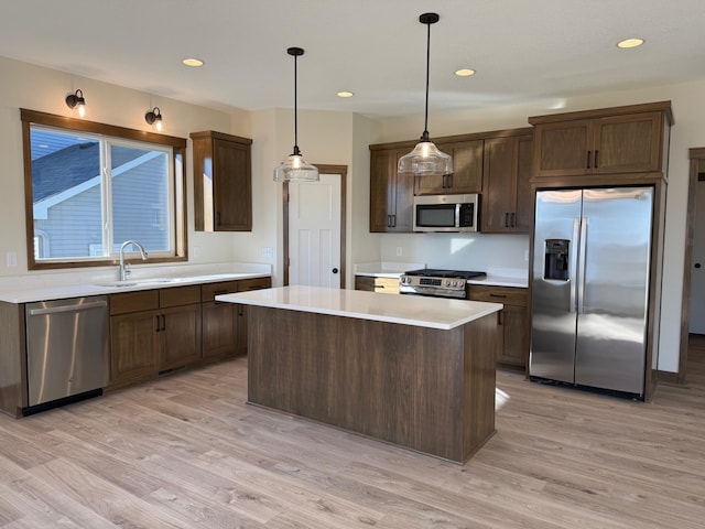 13077 Opal St NE, Blaine, MN 55449 - kitchen featuring light wood-style flooring, stainless steel appliances, light countertops, and a sink