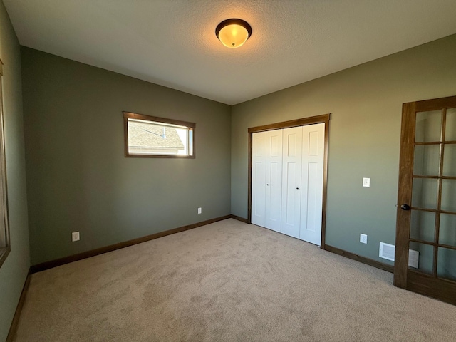 13077 Opal St NE, Blaine, MN 55449 - unfurnished bedroom with a closet, baseboards, a textured ceiling, and carpet flooring