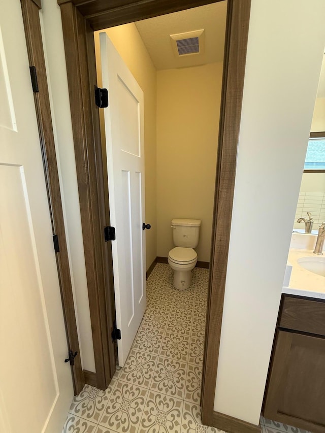 13077 Opal St NE, Blaine, MN 55449 - bathroom with tile patterned floors, visible vents, toilet, baseboards, and vanity