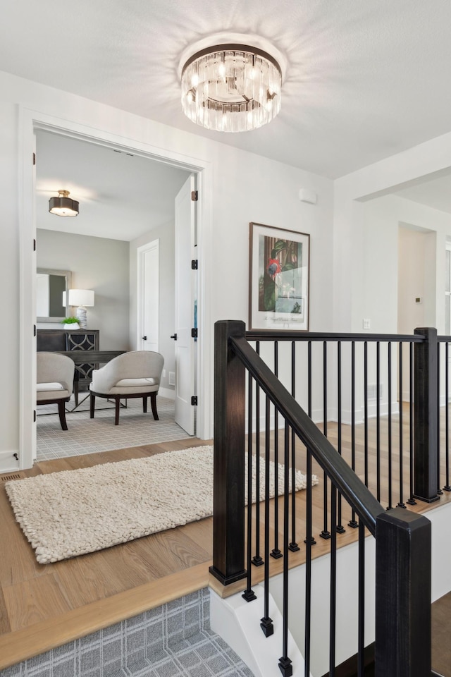 staircase with an inviting chandelier