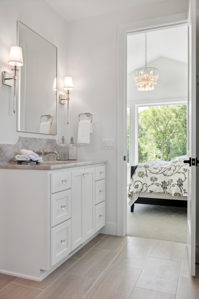 bathroom featuring lofted ceiling, vanity, and a chandelier