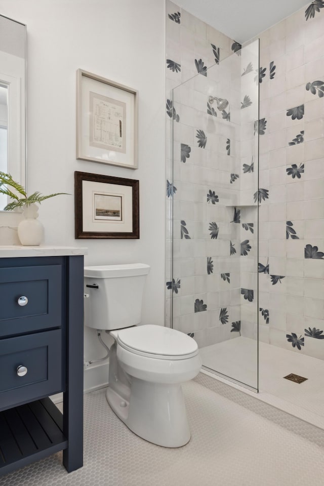 bathroom featuring walk in shower, vanity, toilet, and tile patterned floors