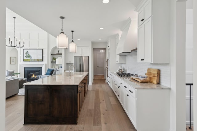 kitchen with light wood-type flooring, white cabinets, and stainless steel appliances