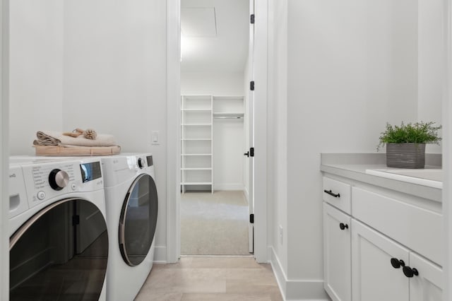 laundry room featuring cabinets and washer and clothes dryer