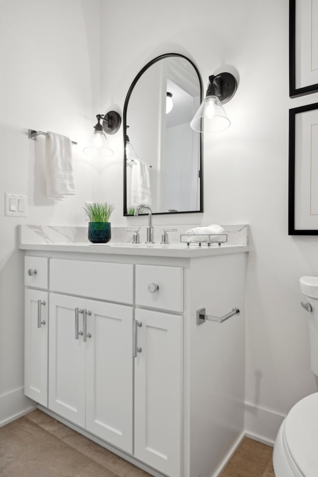 bathroom with tile patterned flooring, vanity, and toilet