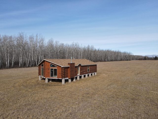 view of side of property featuring a yard and a shingled roof