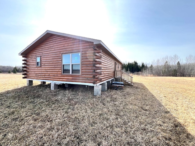 view of property exterior featuring a yard and log exterior