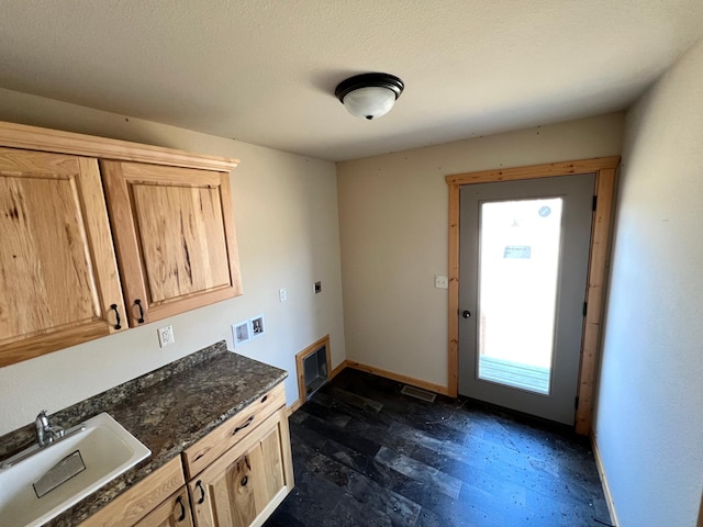 kitchen featuring baseboards, light brown cabinetry, dark wood finished floors, and a sink