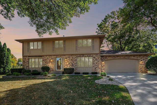 view of front of property featuring a garage and a yard