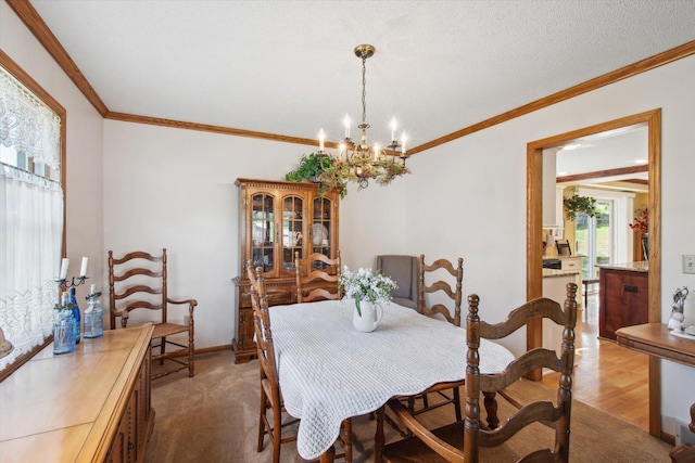 dining space with wood-type flooring, a notable chandelier, ornamental molding, and a textured ceiling