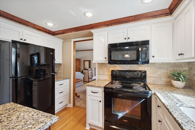 kitchen with black appliances, light hardwood / wood-style flooring, and white cabinetry