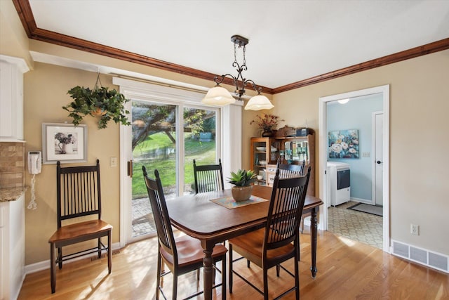 dining space with washer / dryer, crown molding, and light hardwood / wood-style floors