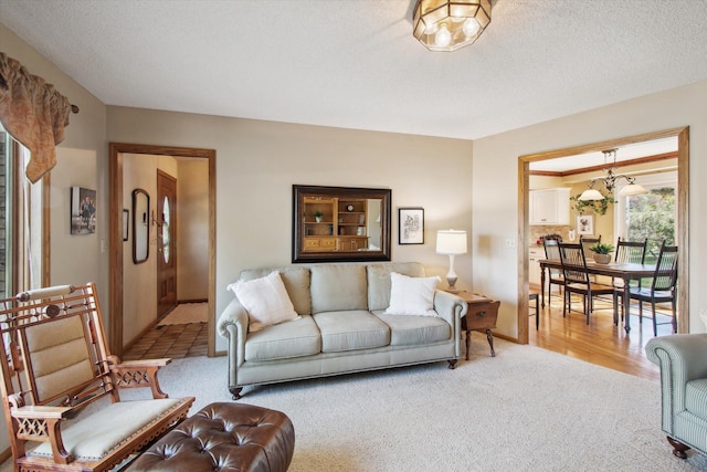 living room with a textured ceiling and light wood-type flooring