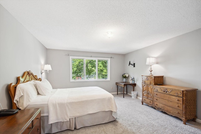 bedroom featuring light colored carpet and a textured ceiling