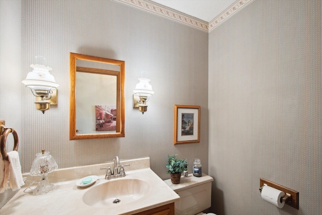 bathroom featuring ornamental molding, vanity, and toilet