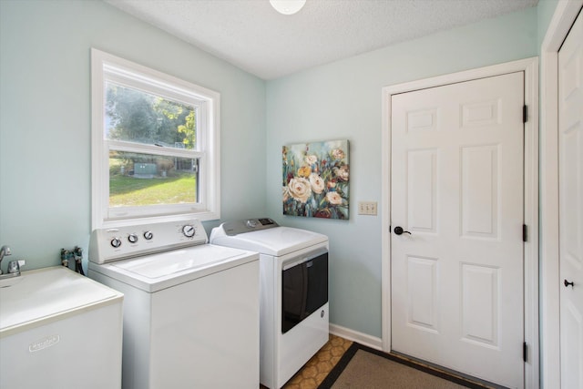 laundry room featuring a textured ceiling, sink, and washing machine and dryer