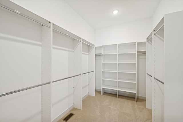 spacious closet featuring light colored carpet and visible vents