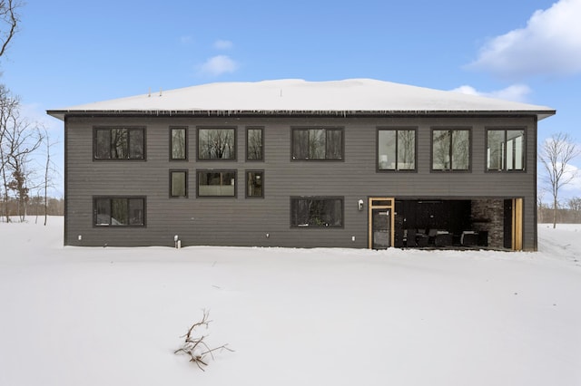 view of snow covered rear of property