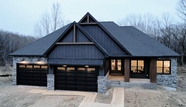 view of front of home featuring a garage, roof with shingles, board and batten siding, and driveway