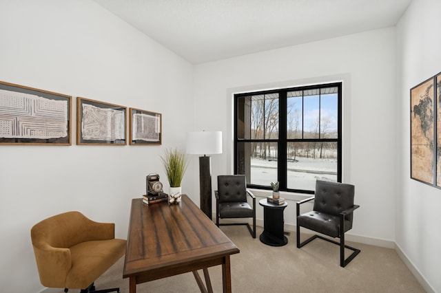 sitting room with baseboards and light carpet