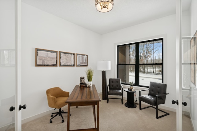 office space featuring an inviting chandelier, french doors, light colored carpet, and baseboards